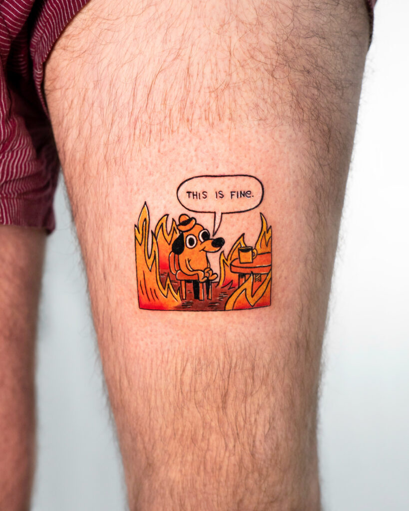 Tattoo of a cartoon illustration, Dog in fire, saying 'This is fine'.