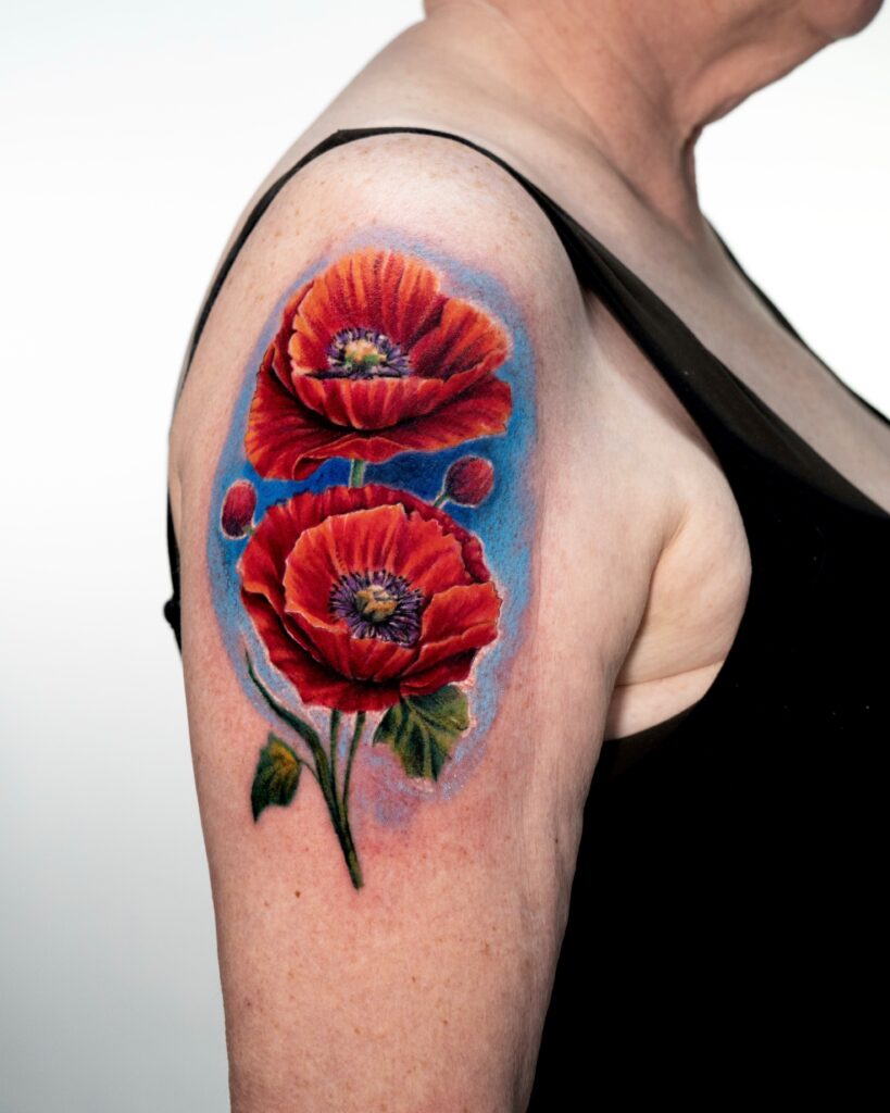 Vibrant red poppy tattoo on arm